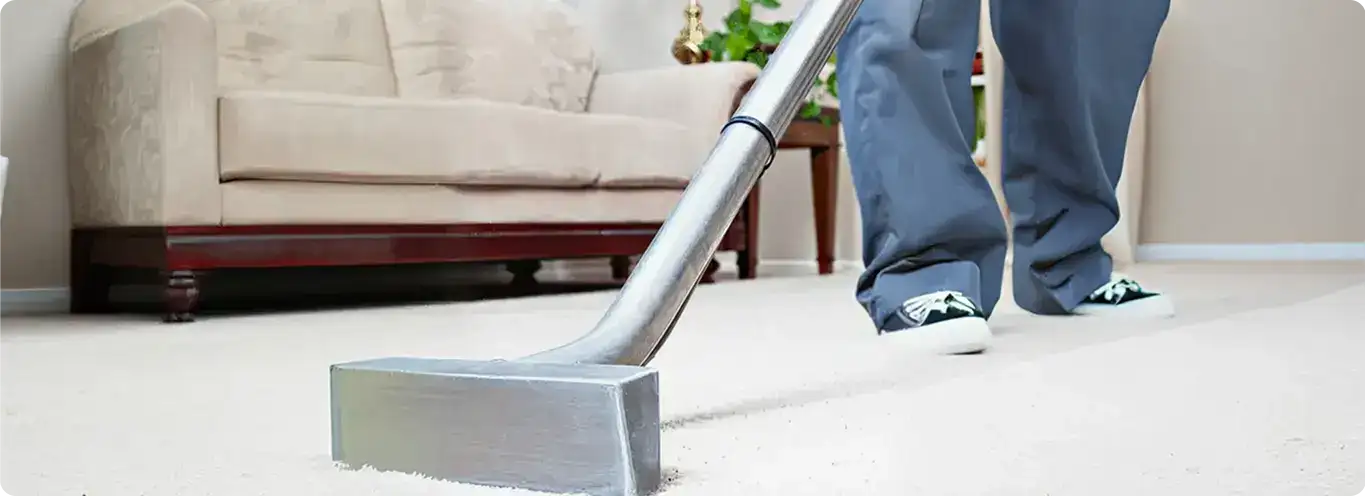 Carpet cleaning technician using a hot-water extraction wand on a light-colored carpet in a living room, Yonkers, NY.